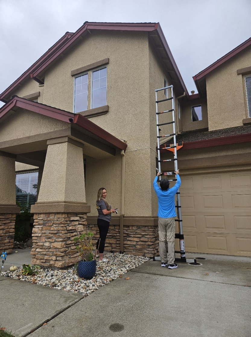 Man setting up ladder getting ready to clean a customer's gutters.