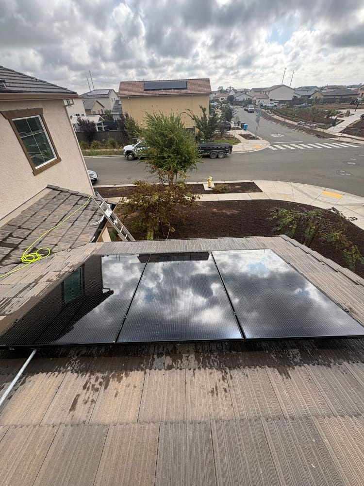 Shiny clean solar panel reflecting the clouds in the sky.